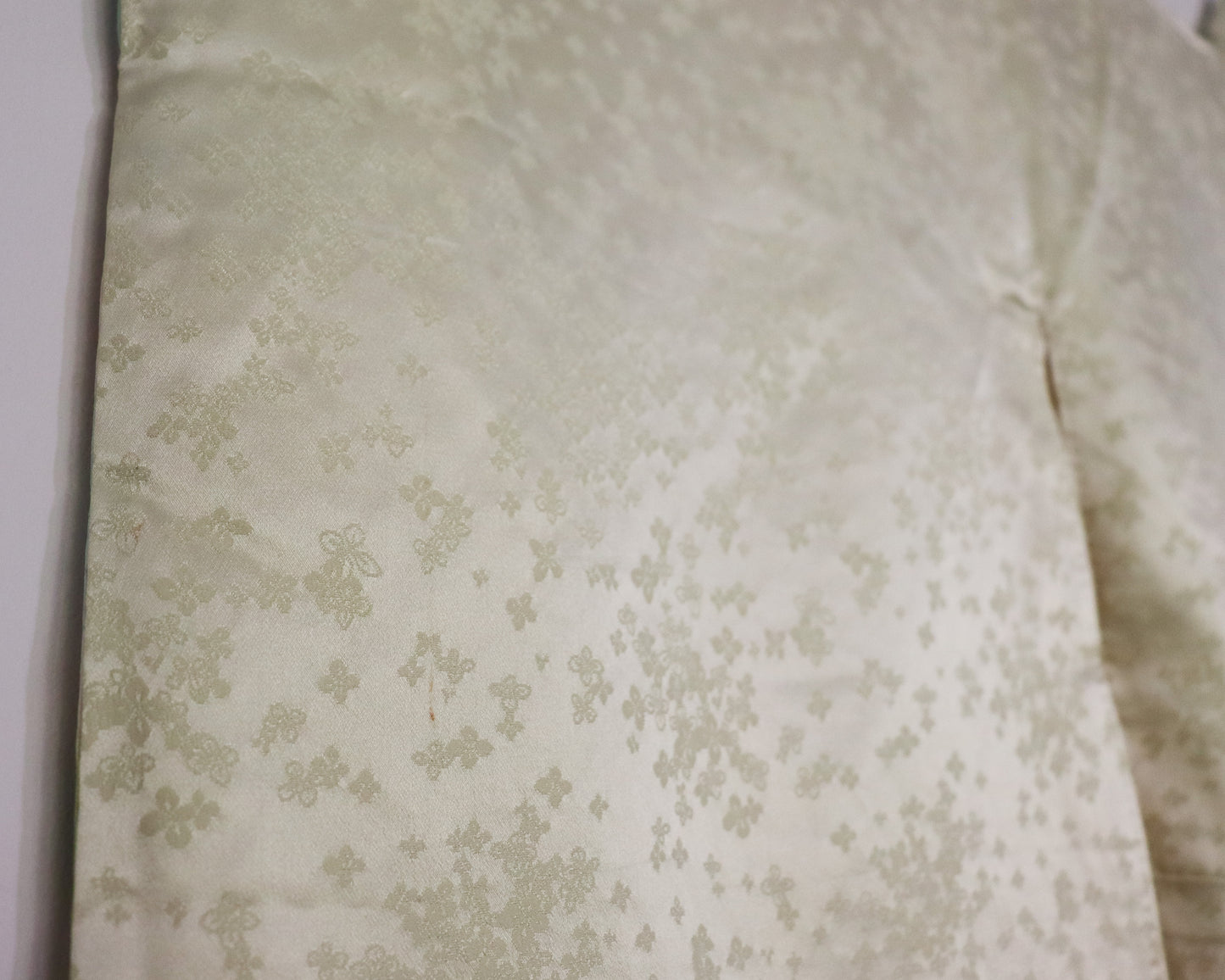 Vintage silk kimono in light pastel green with cute floral pattern. up close image of the fabric.