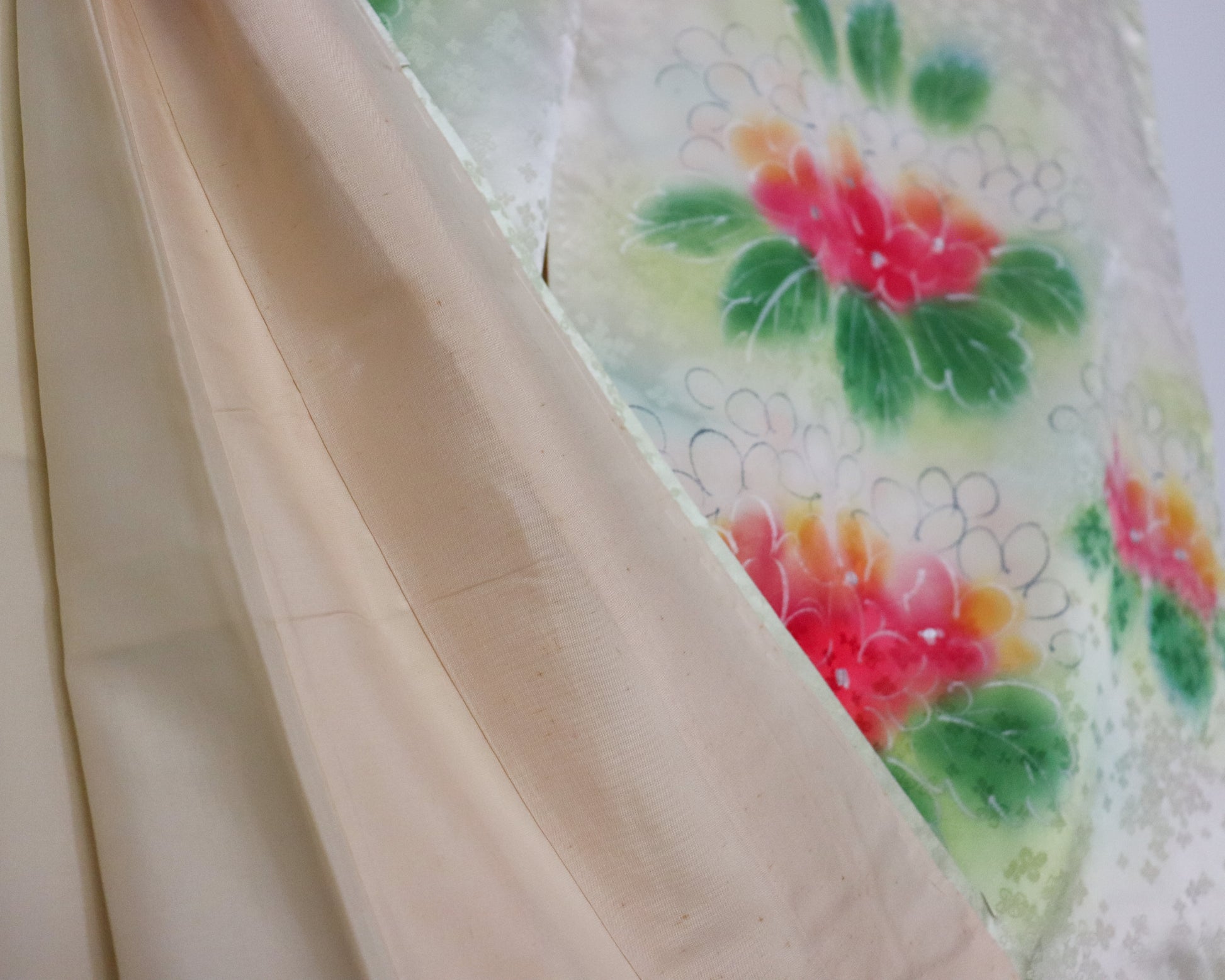 Vintage silk kimono in light pastel green with cute floral pattern. close up image of the fabric and lining.