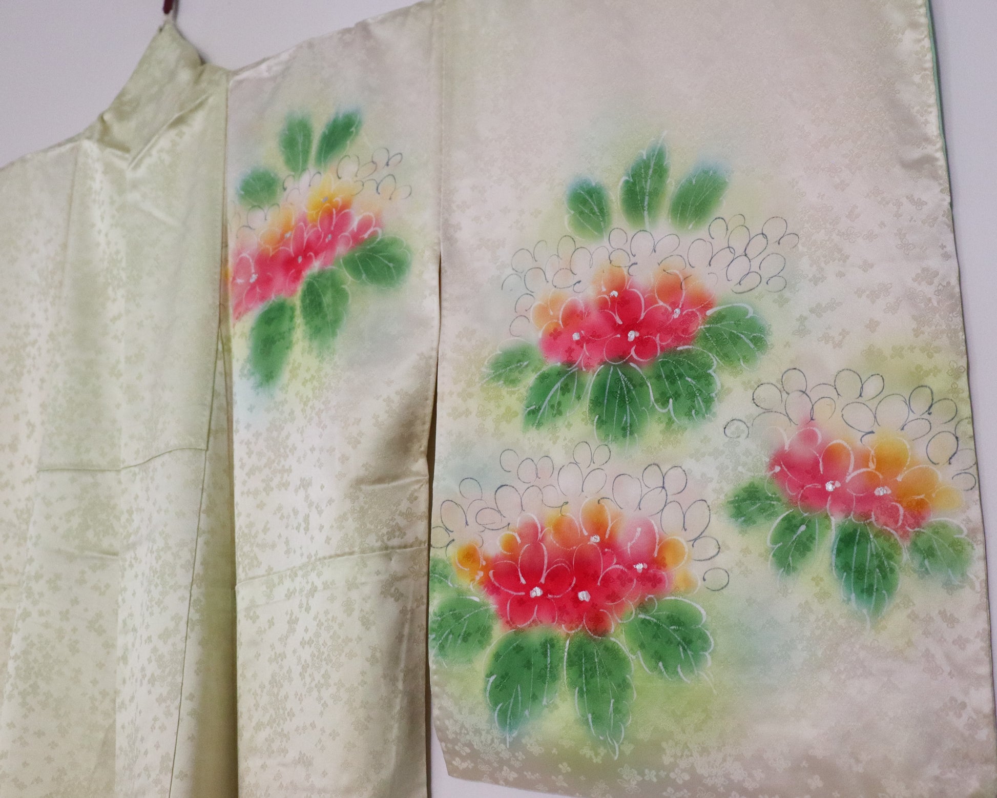 Vintage silk kimono in light pastel green with cute floral pattern. up close of the sleeve.