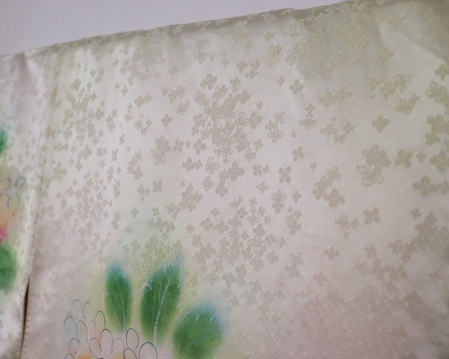 Vintage silk kimono in light pastel green with cute floral pattern. up close image of the fabric.