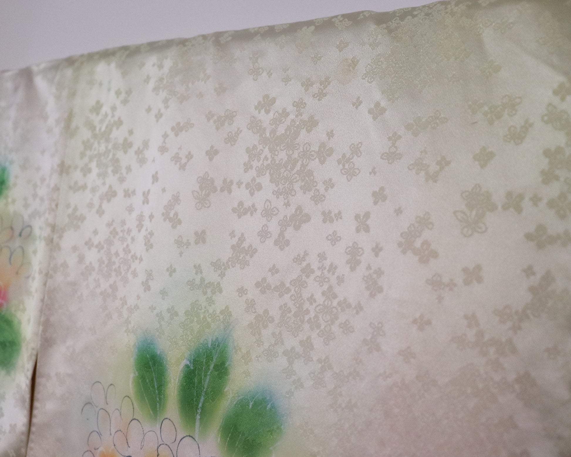 Vintage silk kimono in light pastel green with cute floral pattern. up close image of the fabric.