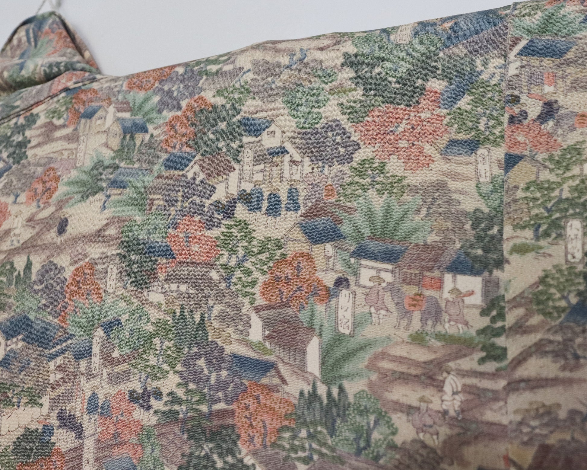 vintage silk kimono with unique pattern of people, buildings and nature.  close up image of the silk kimono fabric.