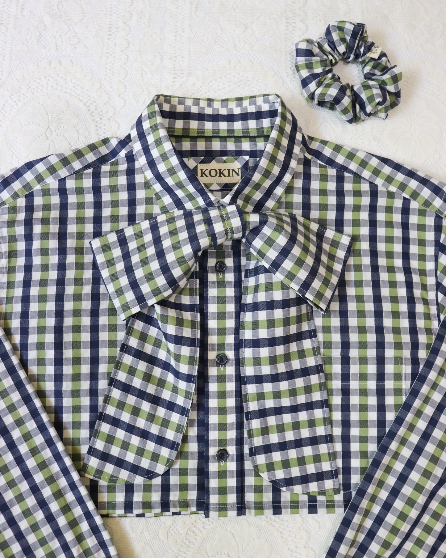 Green and white checkered shirt with a scrunchie on a white background