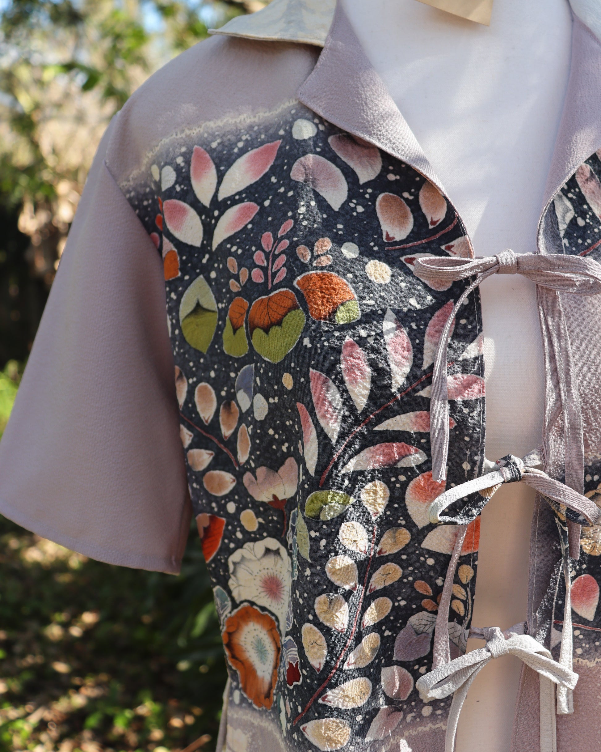Floral-patterned shirt on a mannequin with a blurred outdoor background