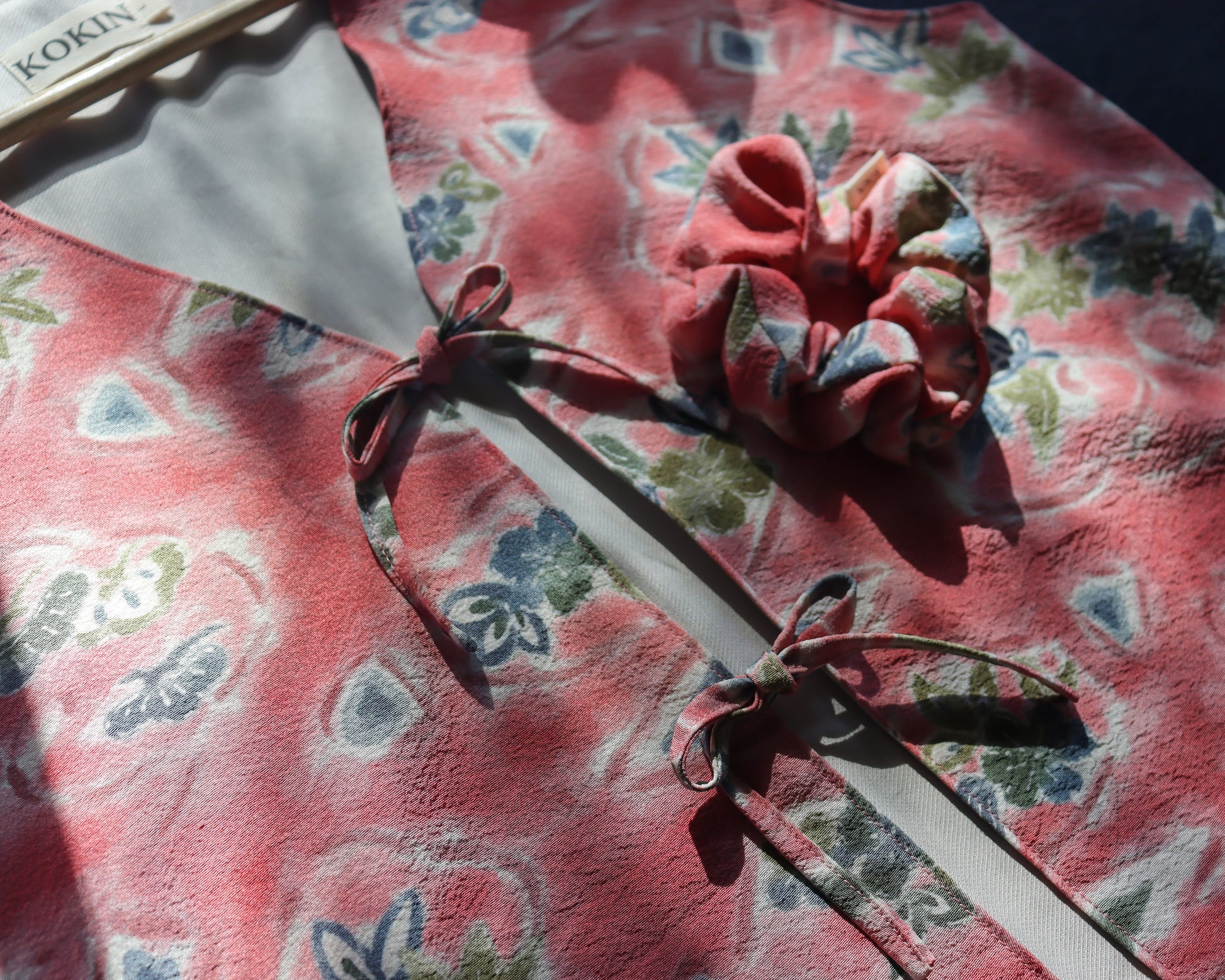 Women's front tie top made from pre-loved silk kimono. Slow fashion. Upcycling. Fully lined with deadstock fabric. Close up image of the silk kimono fabric with a matching scrunchie.