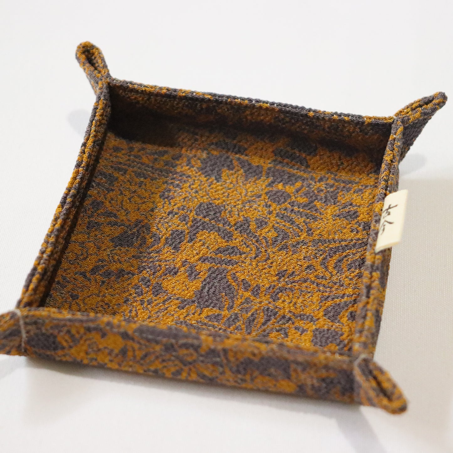 Fabric tray in gold and grey fabric.