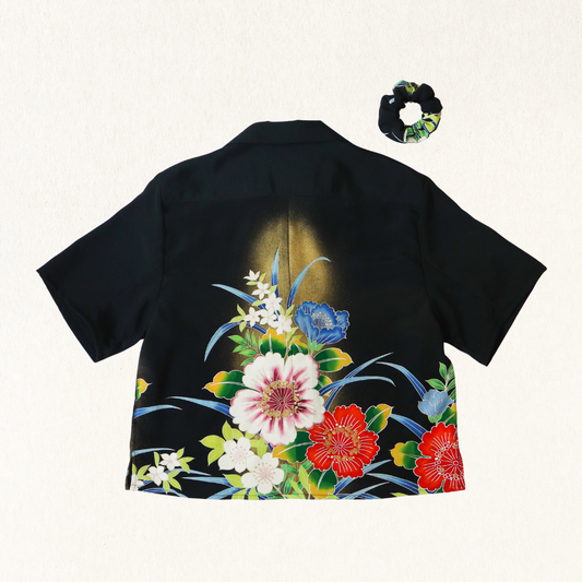 Black shirt with colorful floral design on a white background