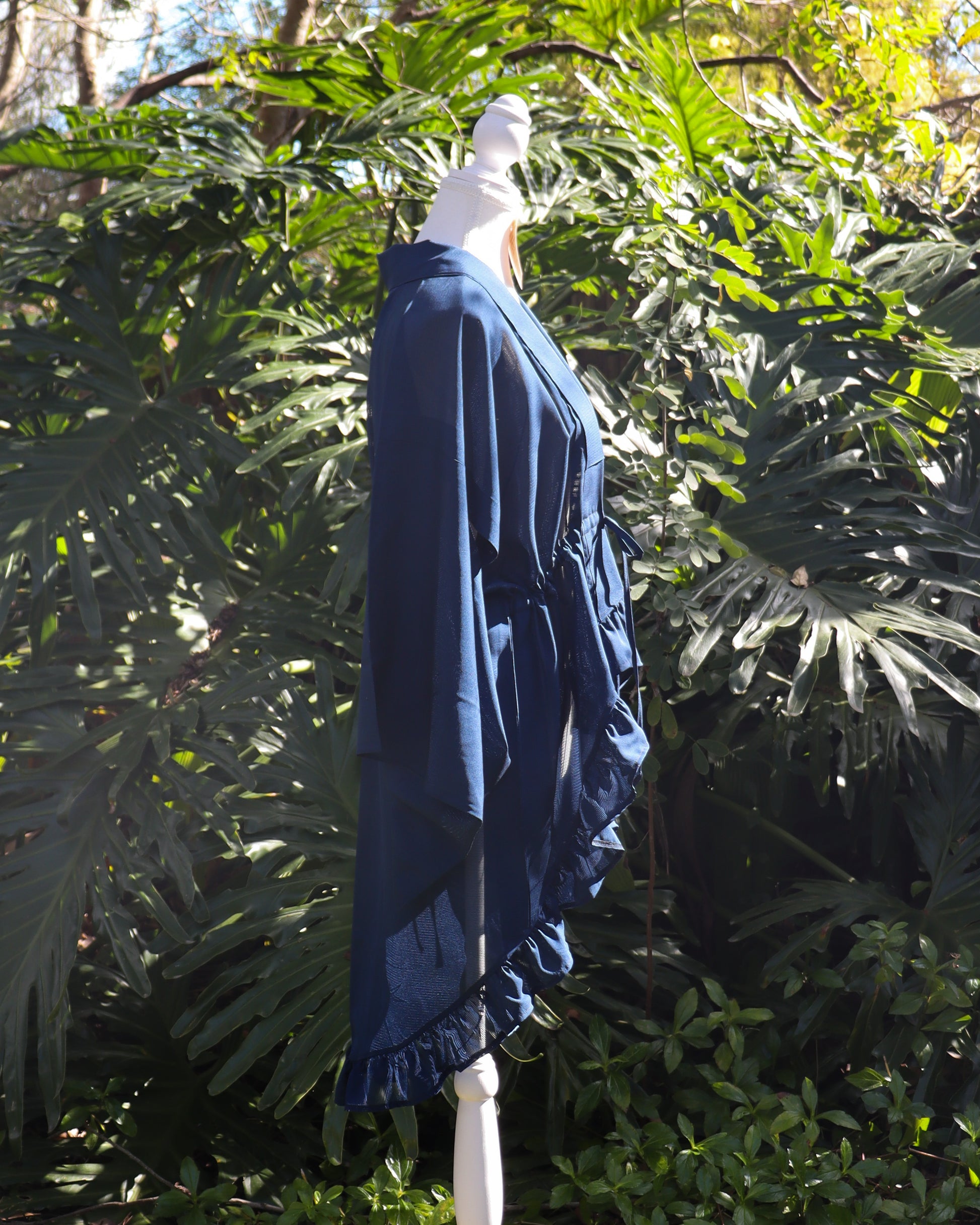 Blue kimono cardigan on a mannequin against a green leafy background