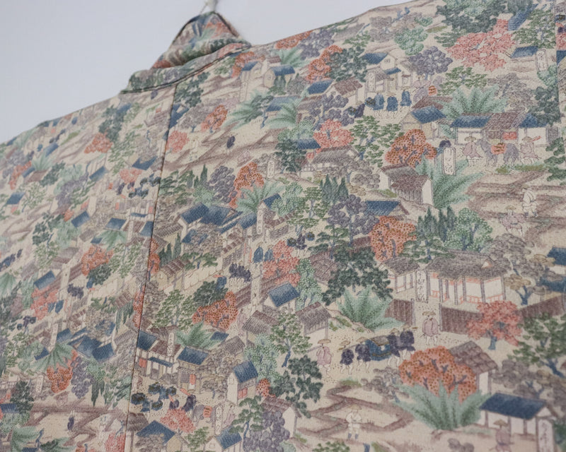 vintage silk kimono with unique pattern of people, buildings and nature.  close up image of the fabric.