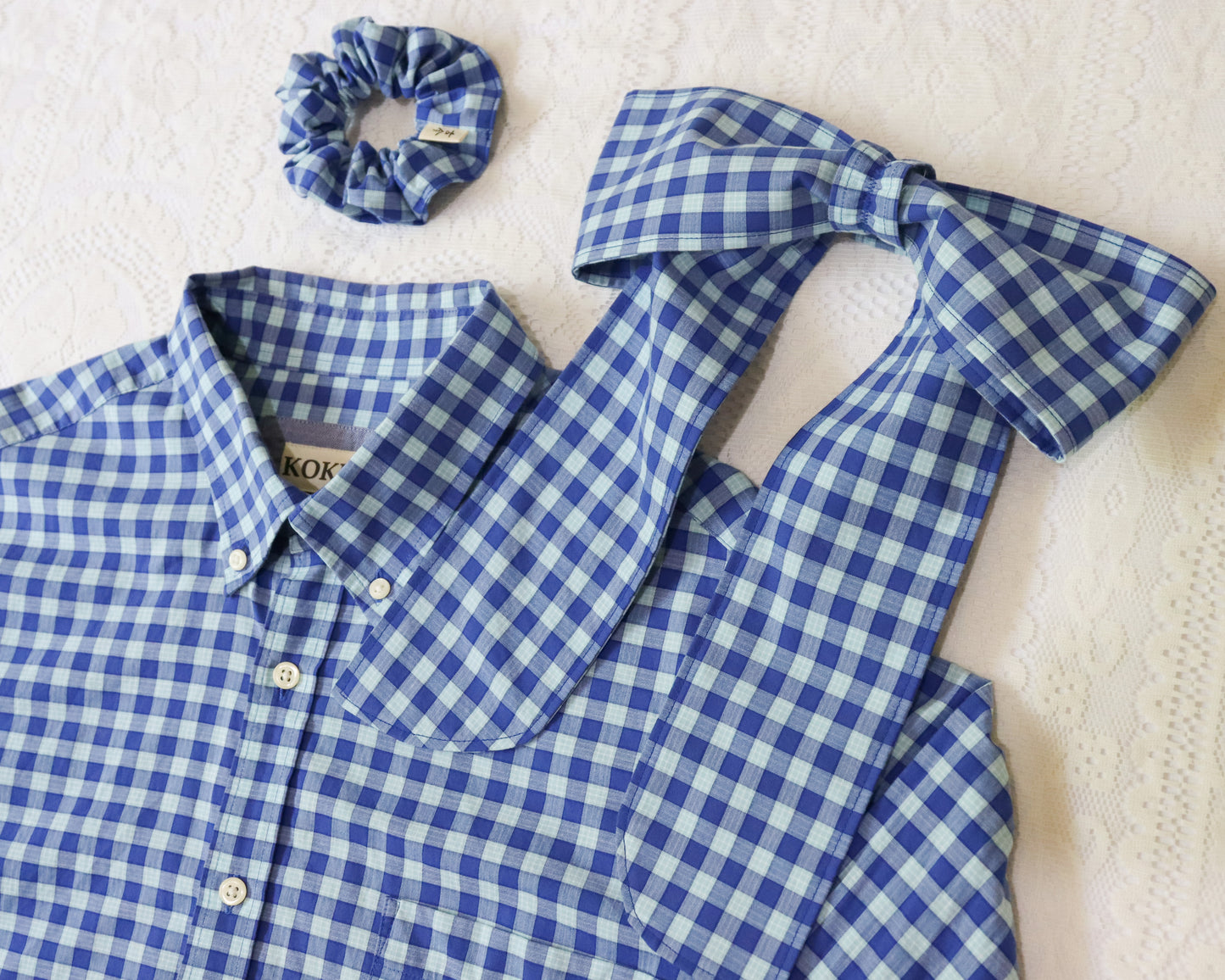 Blue and white checkered shirt with matching bow and scrunchie on a light background