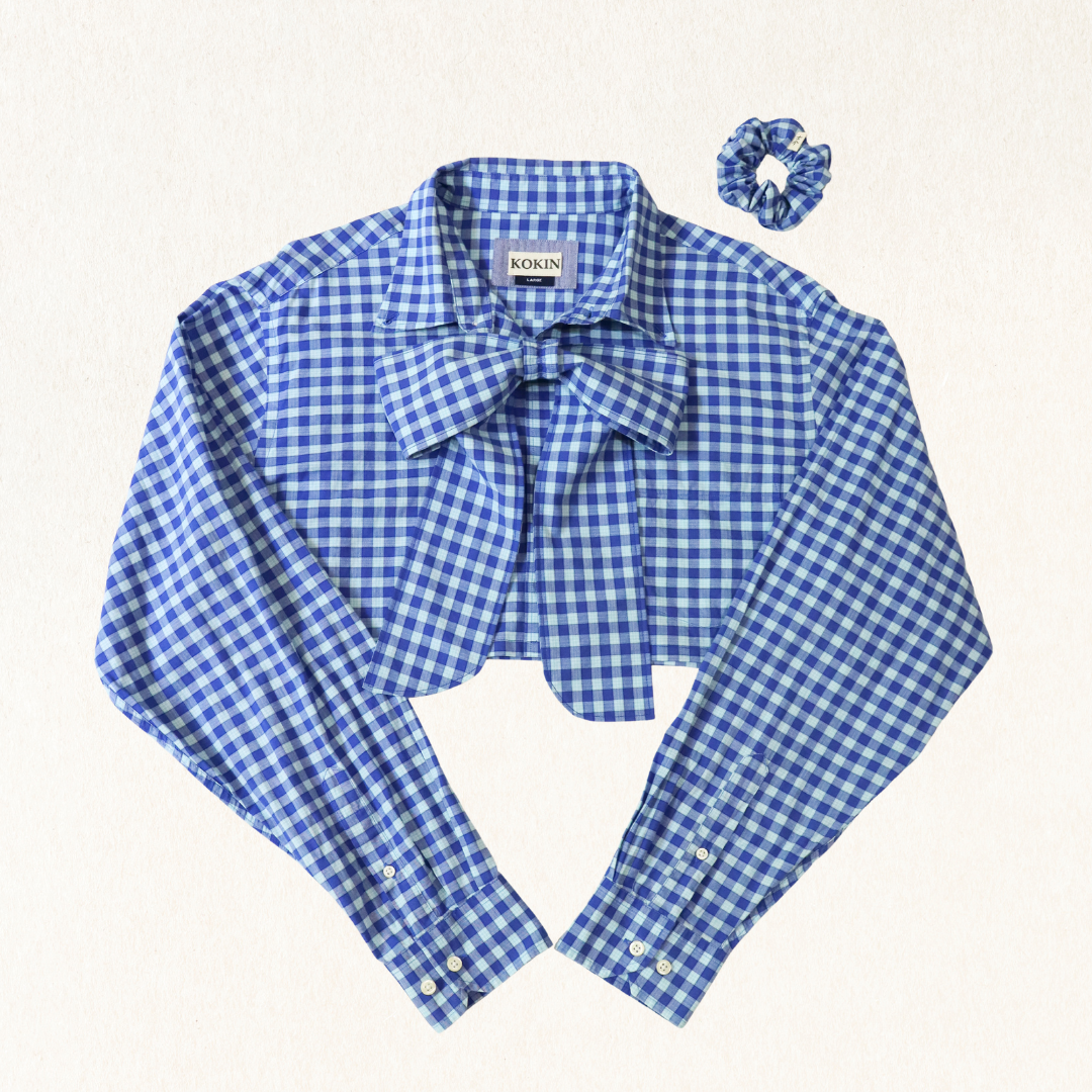 Blue and white checkered shirt with a bow and matching scrunchie on a light background