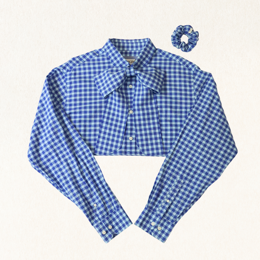 Blue gingham shirt with a bow tie and matching scrunchie on a white background