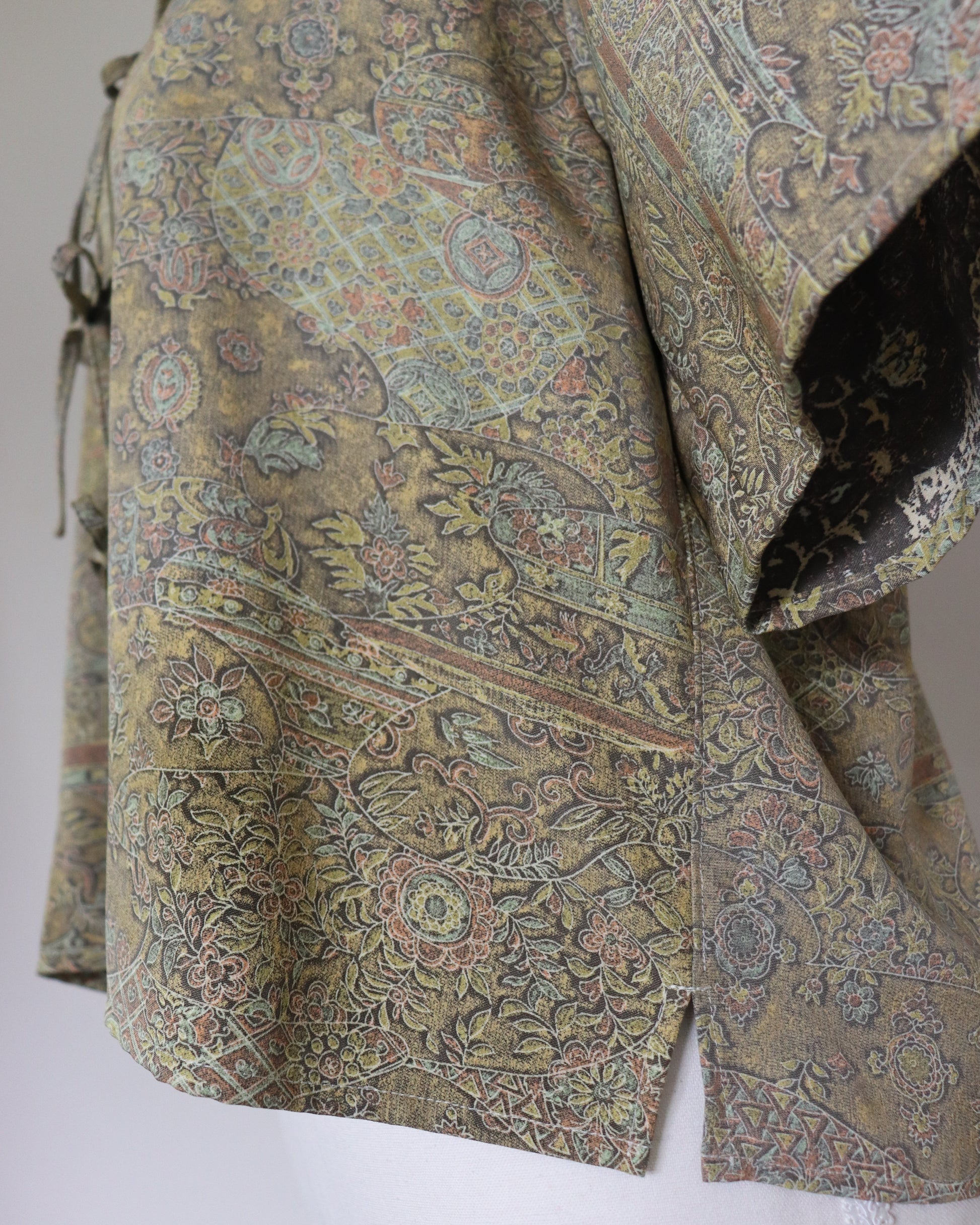 Close-up of a patterned fabric with intricate designs on a plain background