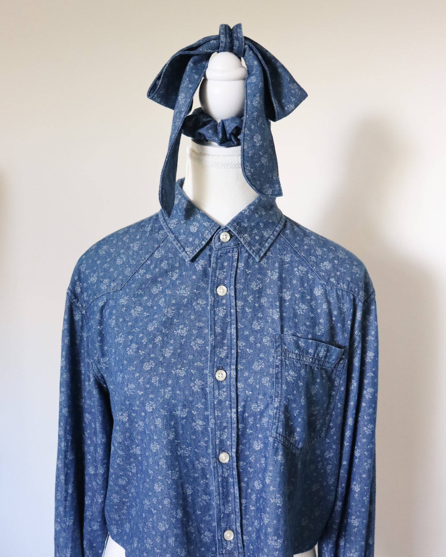 Blue floral shirt with matching headscarf on a mannequin against a plain background