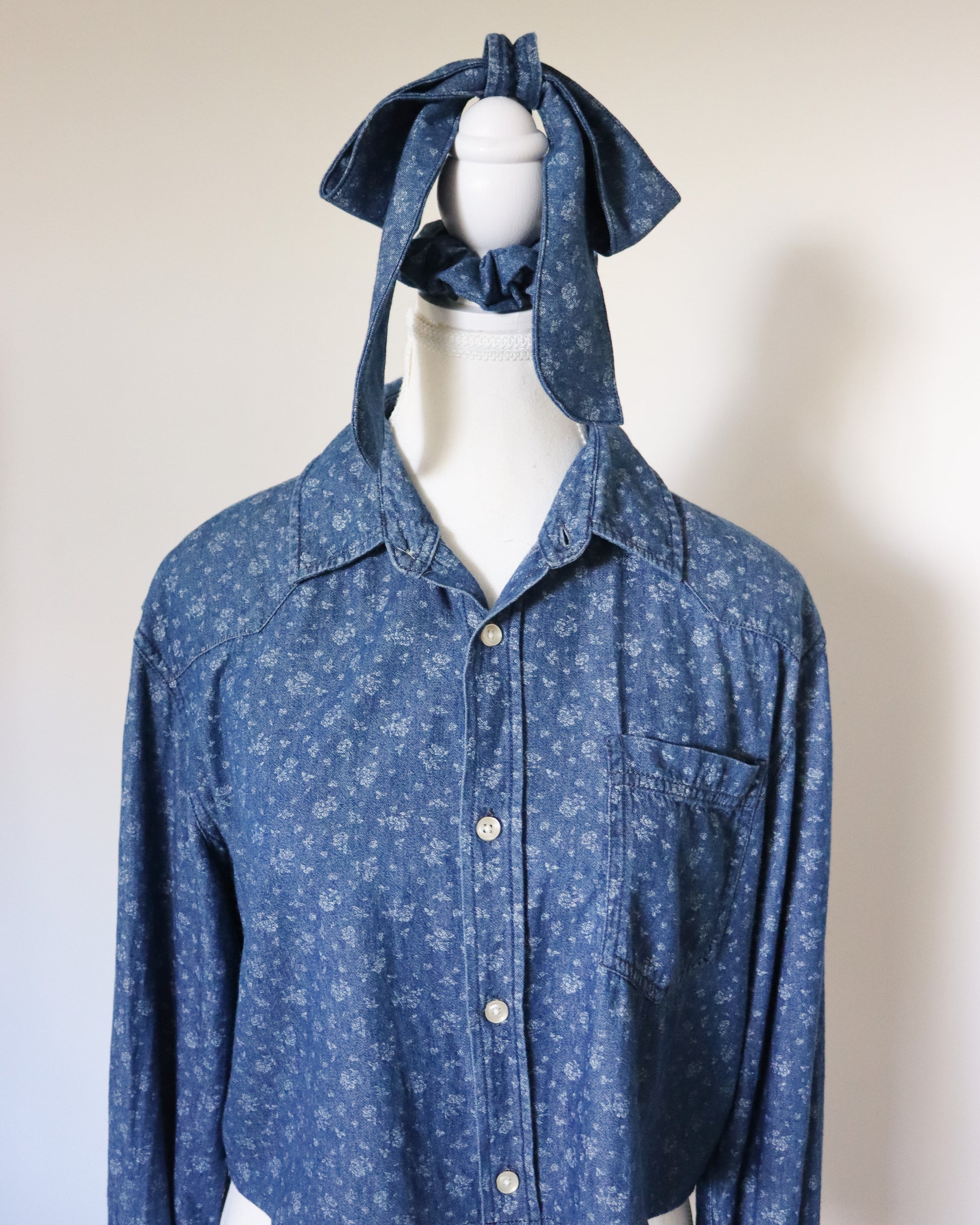 Blue patterned shirt with a hood on a mannequin against a plain background