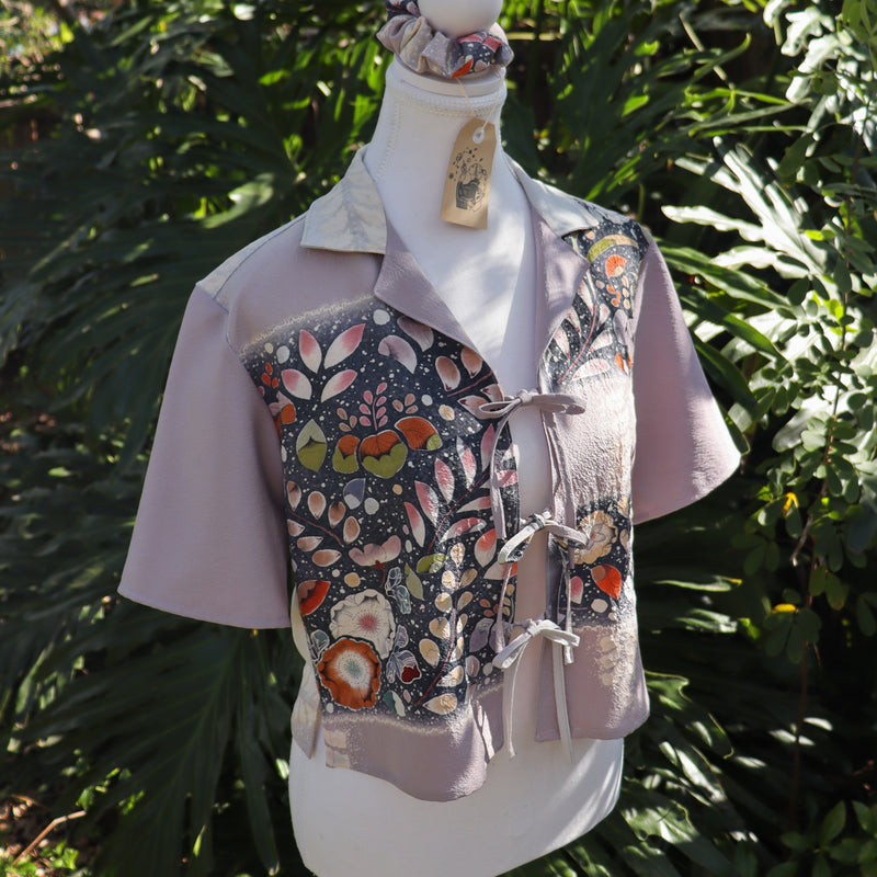 Mannequin wearing a floral-patterned shirt with a green leafy background