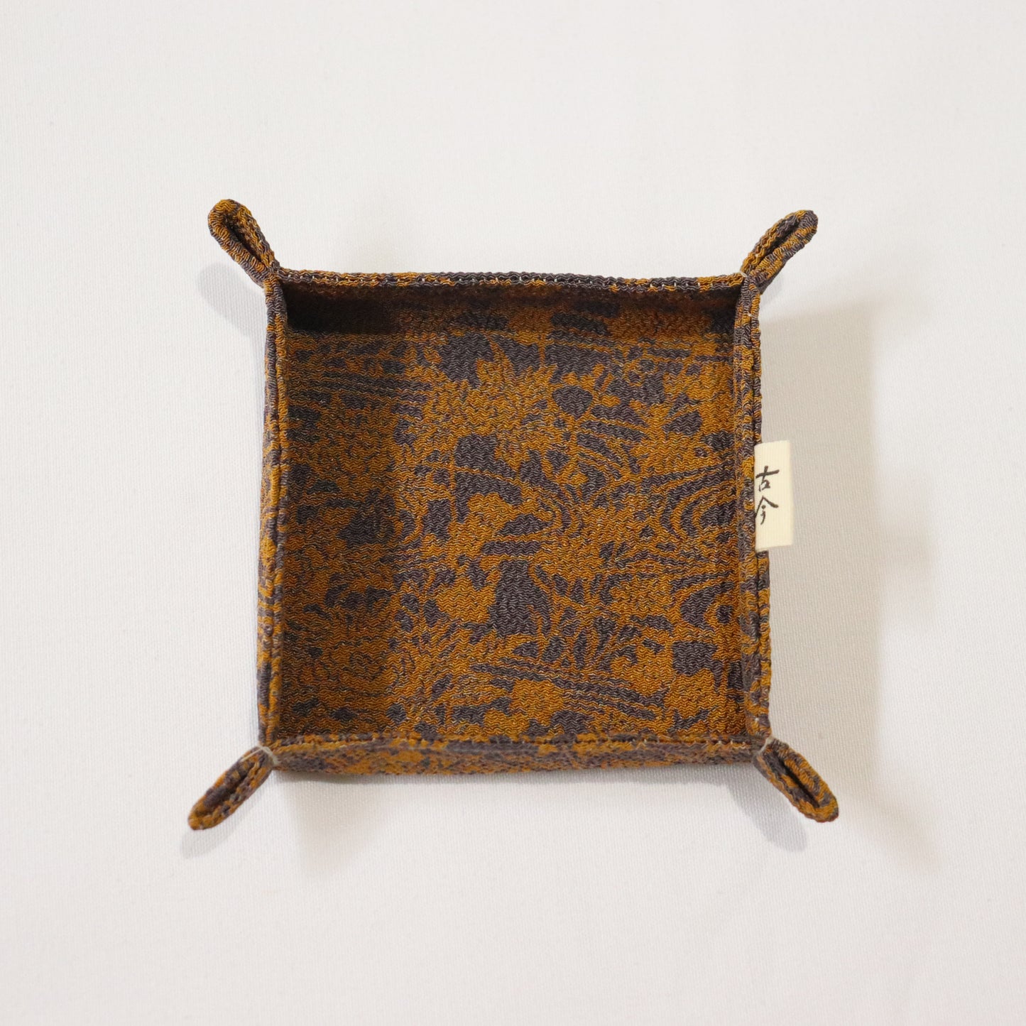 Fabric tray in gold and grey fabric.