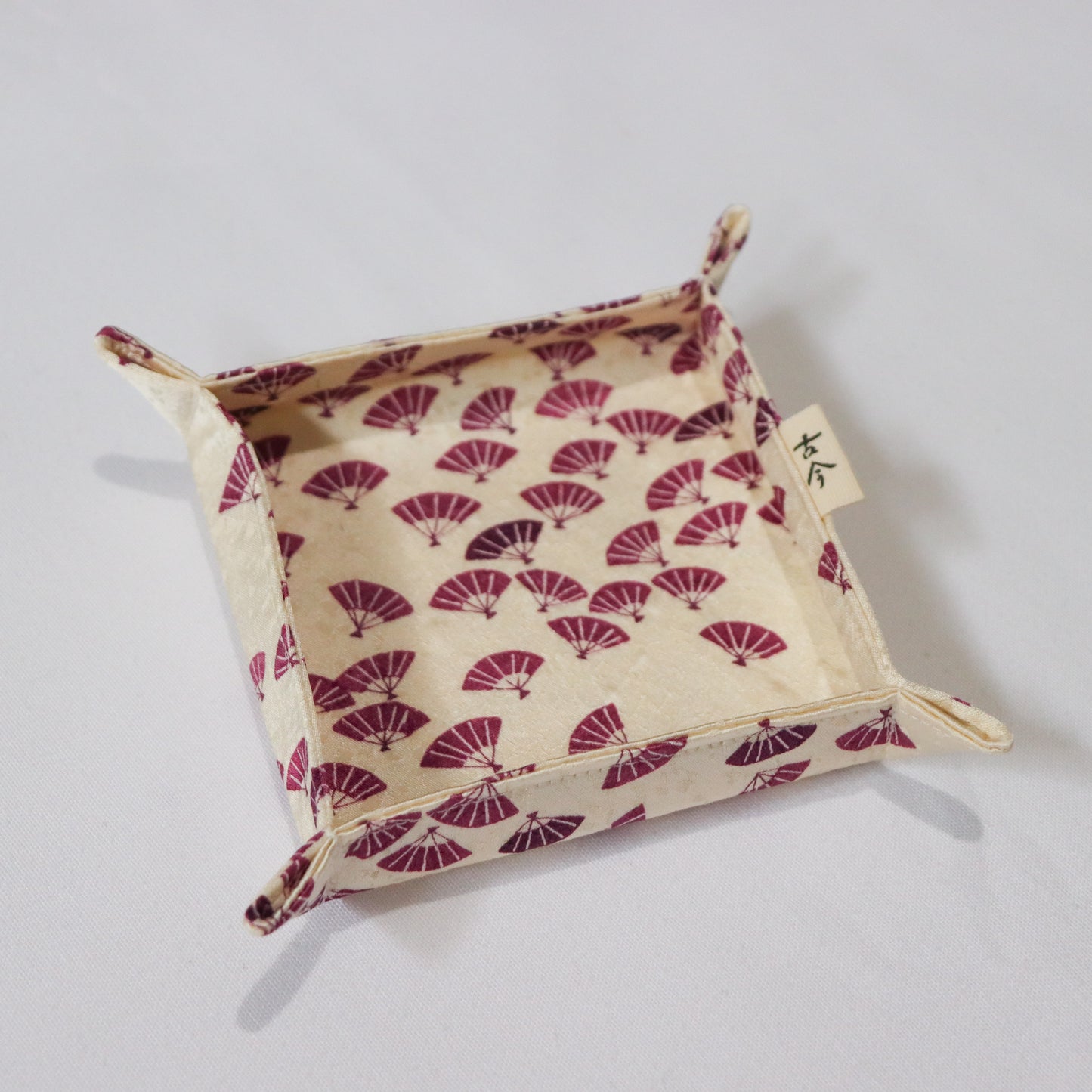 Fabric tray with purple Japanese fan pattern in white background.