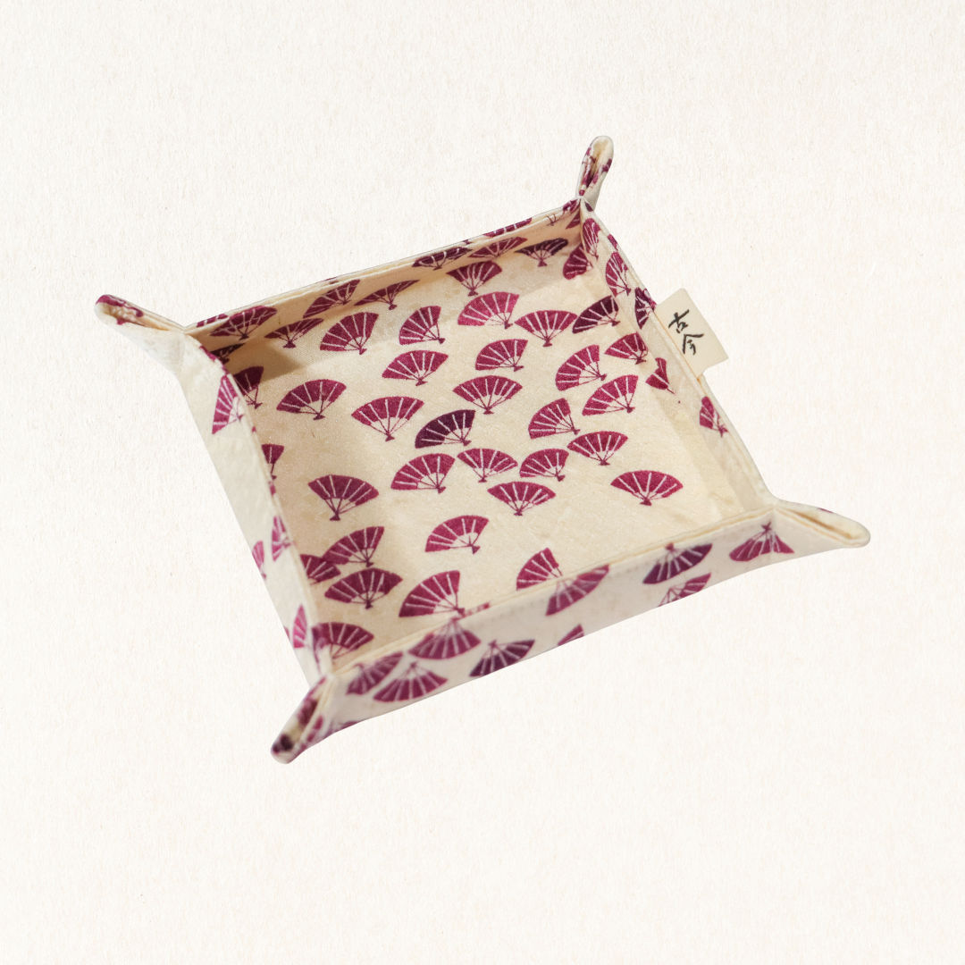 Fabric tray with purple Japanese fan pattern in white background.
