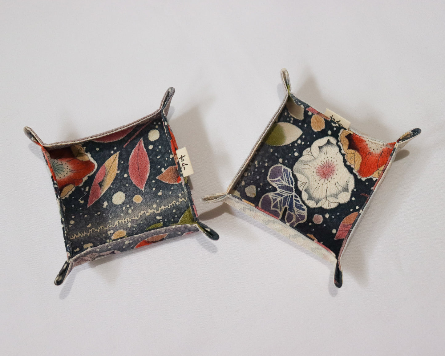 Fabric trays in colourful fabric with nature motif pattern in a white background.