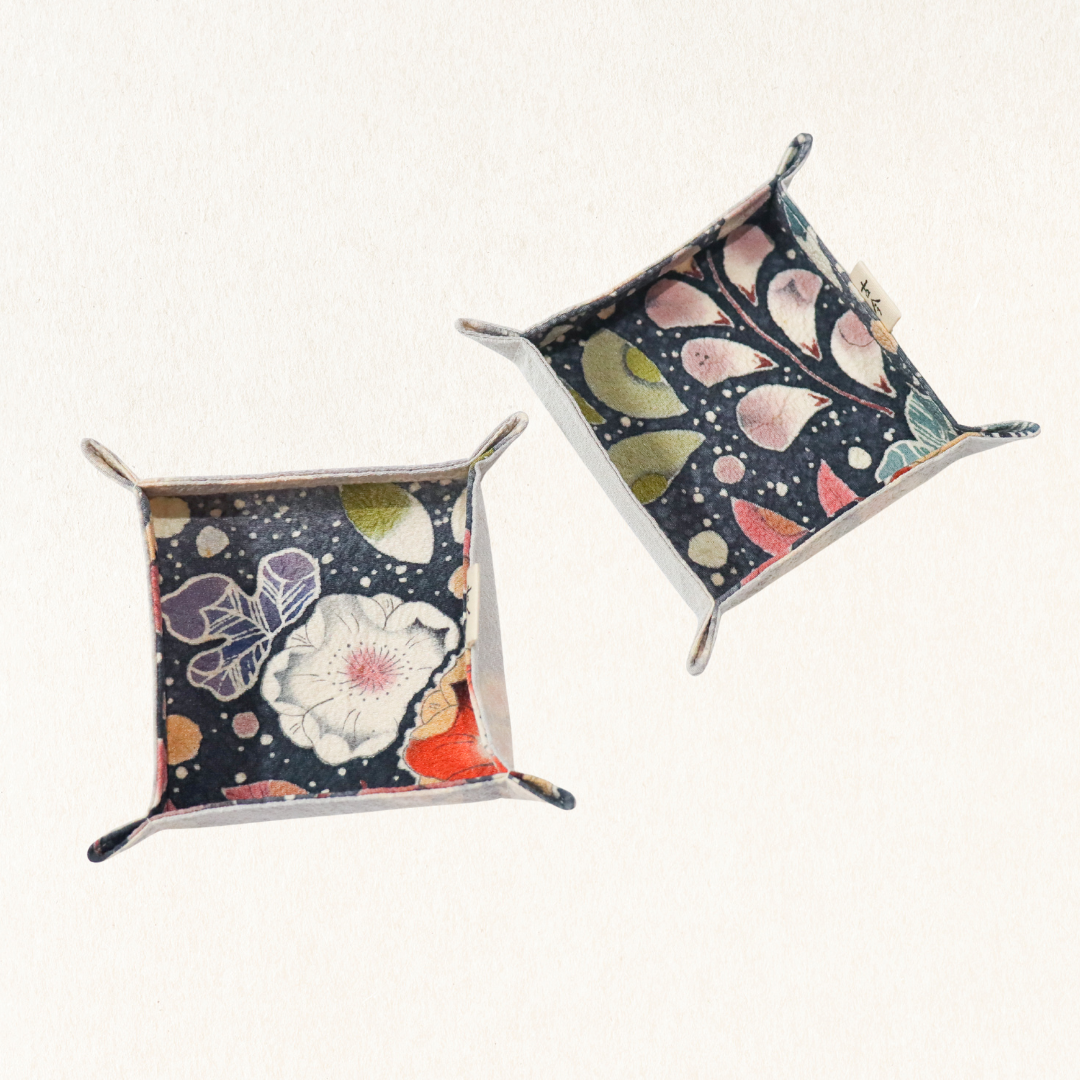 Fabric trays in colourful fabric with nature motif pattern in a white background.
