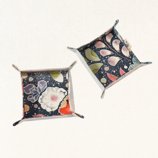 Fabric trays in colourful fabric with nature motif pattern in a white background.