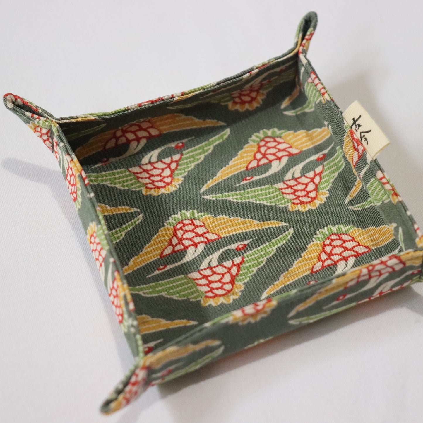 Fabric tray in green fabric with the pattern of cranes.