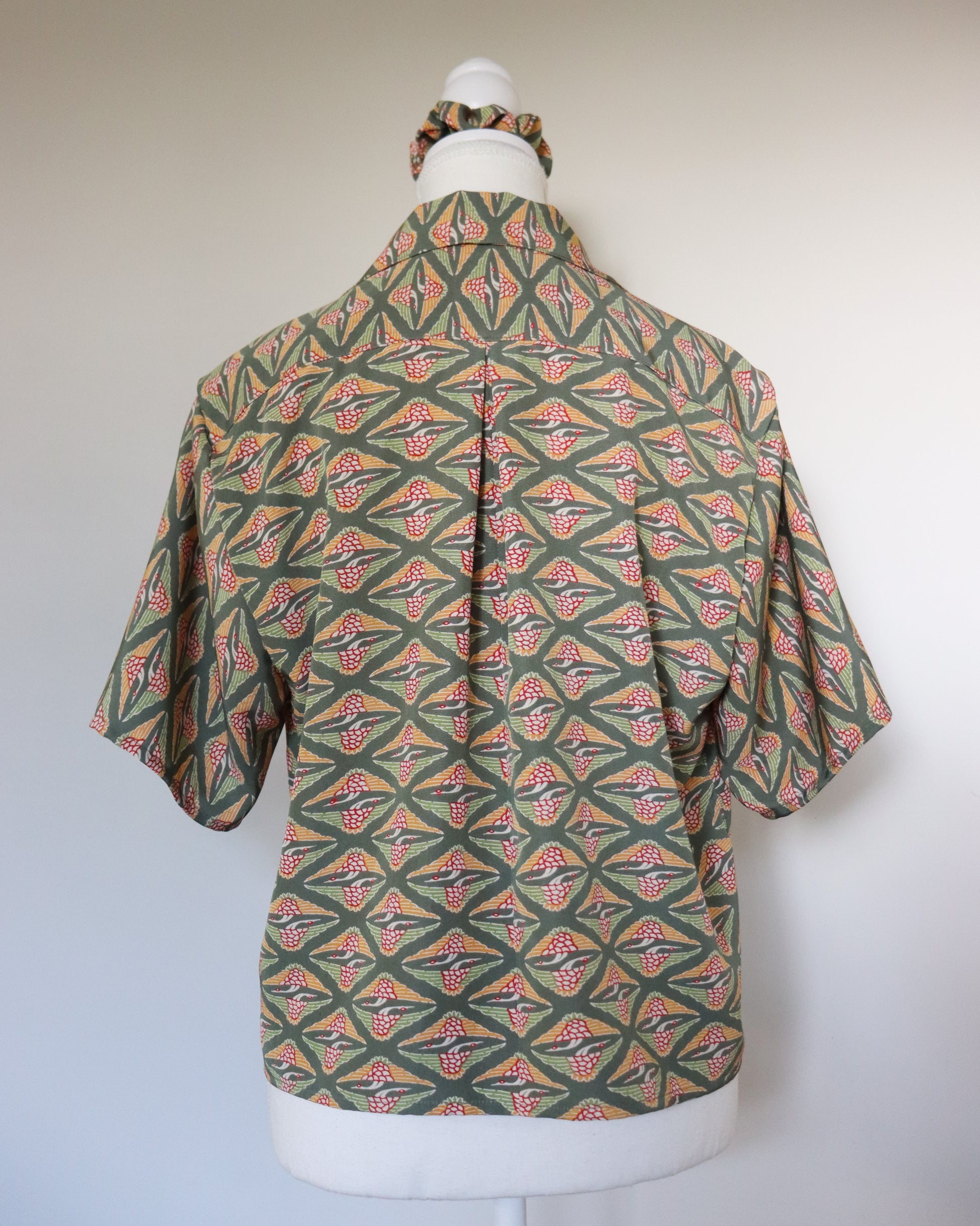 Mannequin wearing a patterned shirt with a plain background