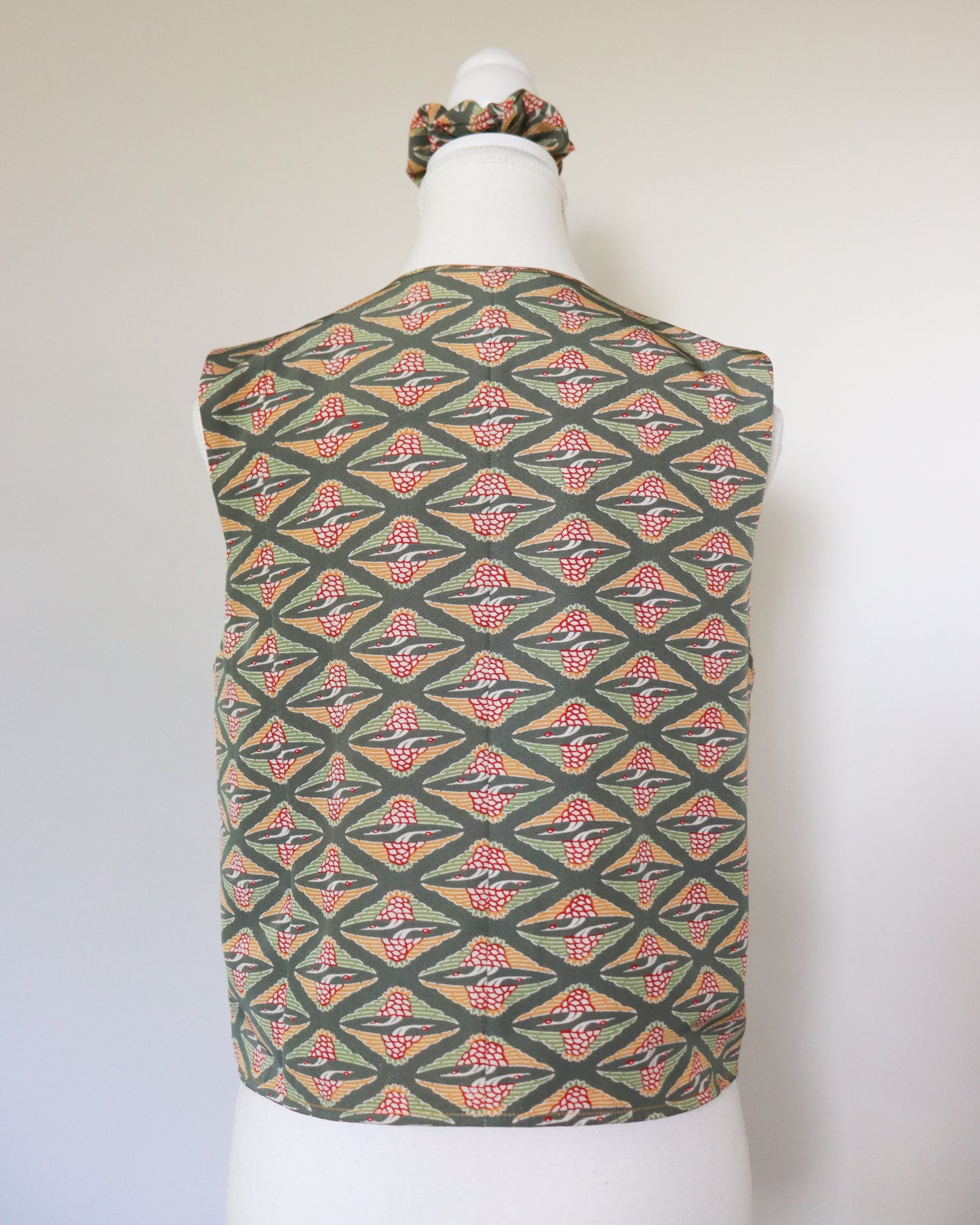 Mannequin wearing a patterned top and scrunchie on a white background
