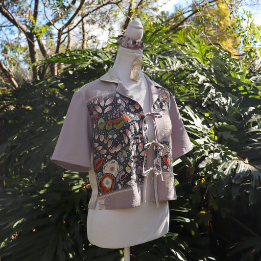 Mannequin wearing a floral-patterned light purple shirt against a natural background