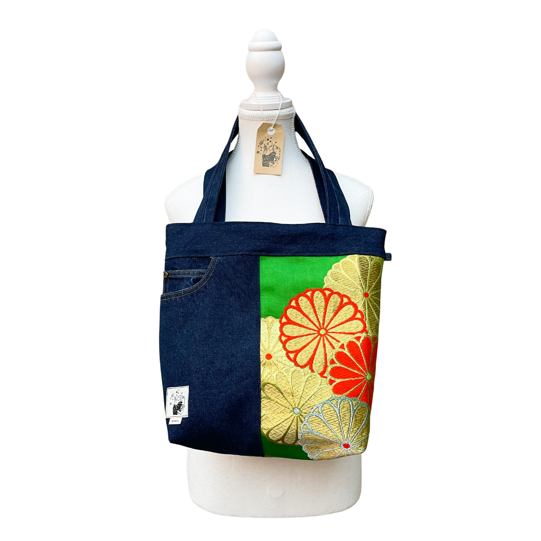 Denim tote bag with floral design on a mannequin against a white background