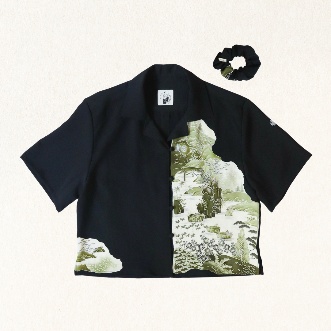 Black shirt with nature print and black scrunchie on a white background