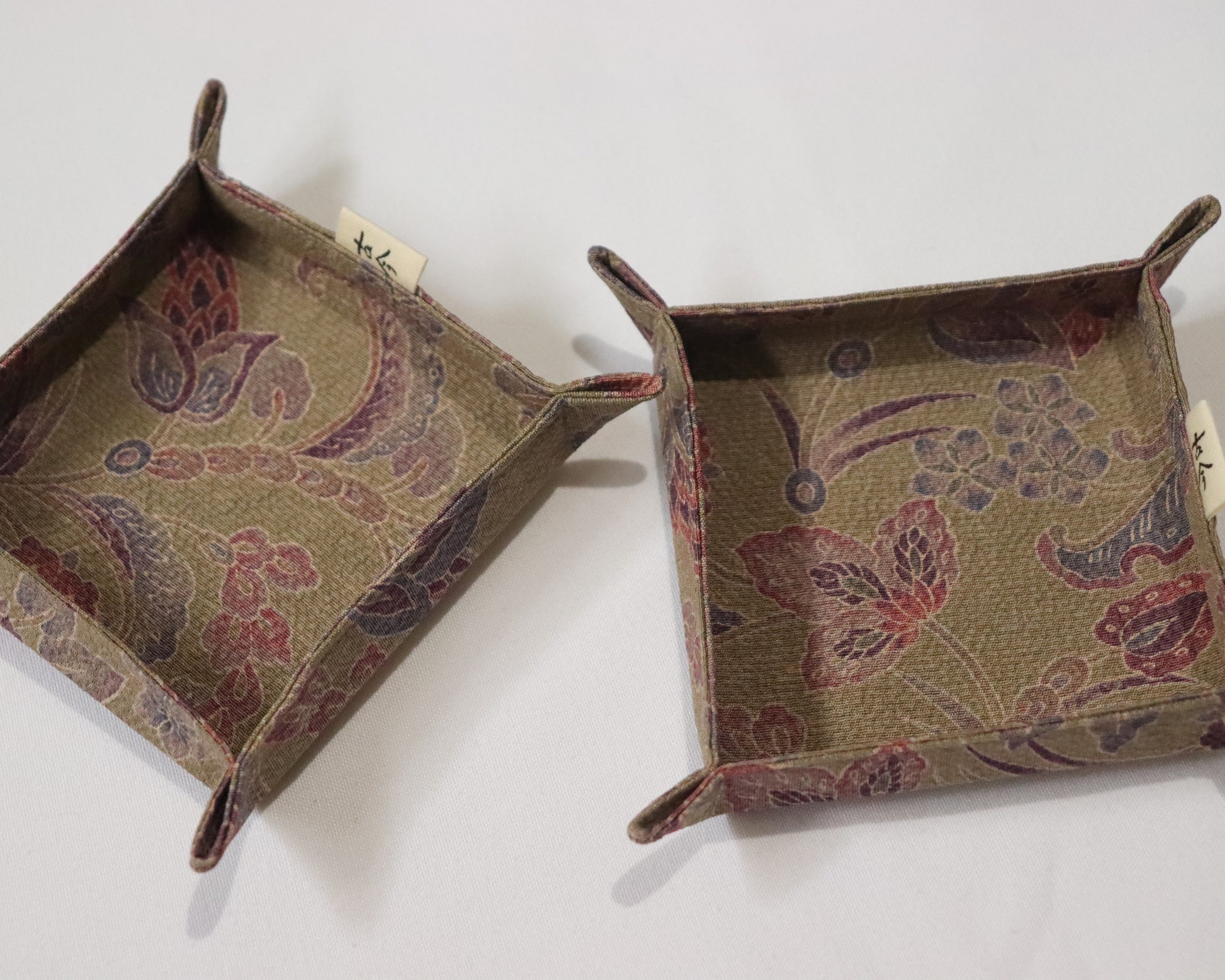 Fabric trays in brown fabric with floral pattern.