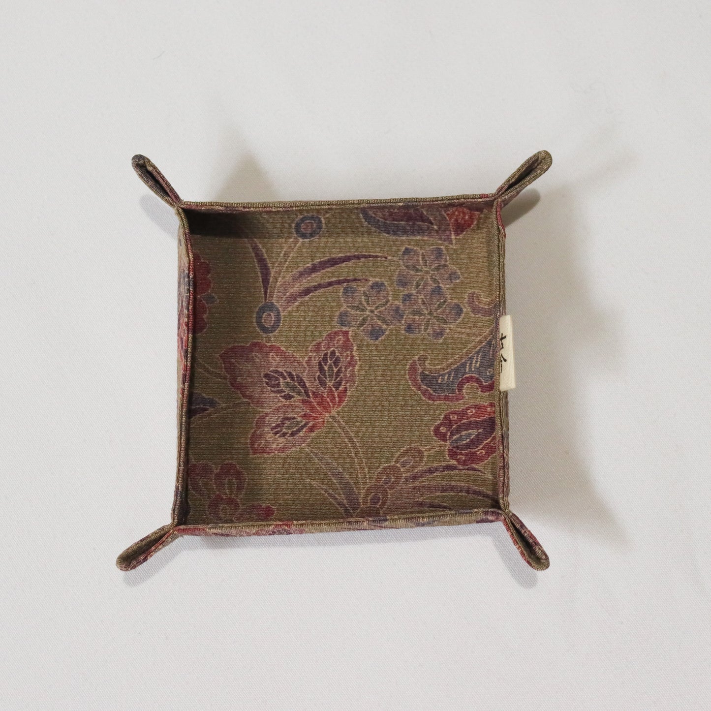 Fabric tray in brown fabric with floral pattern.