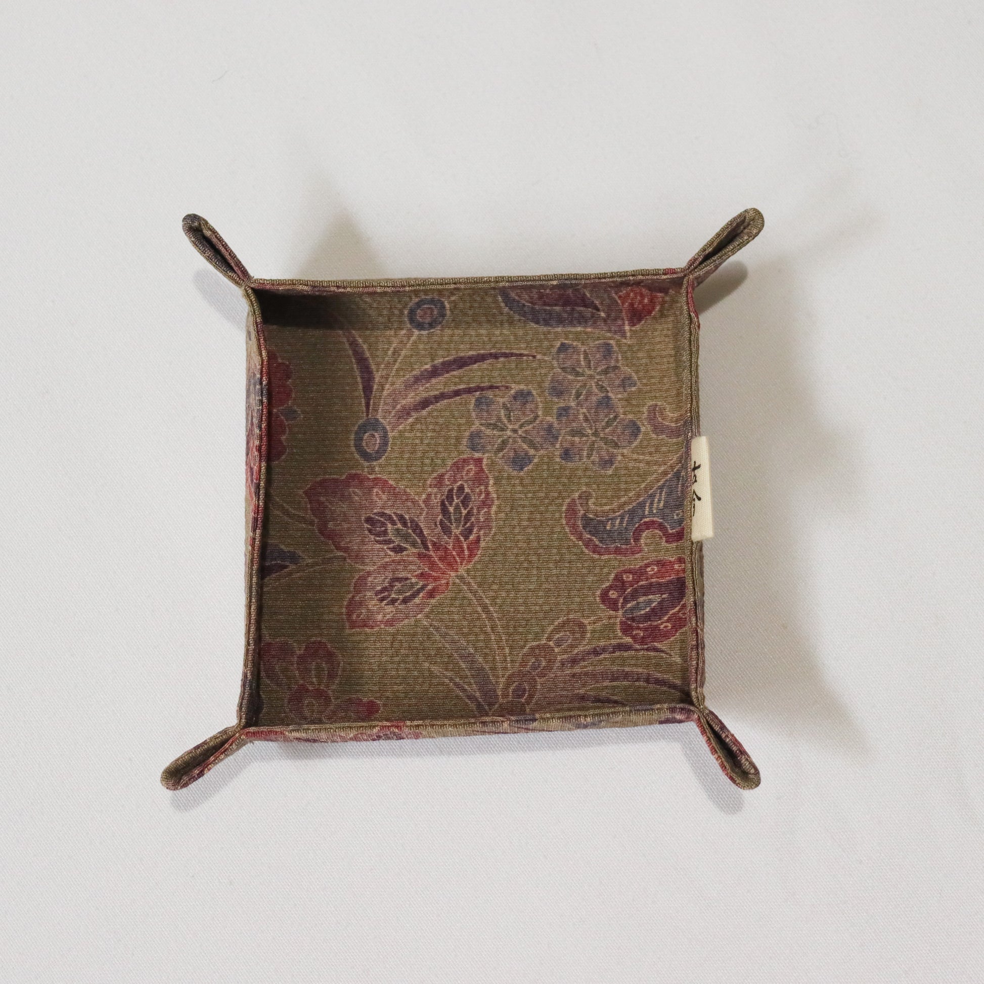 Fabric tray in brown fabric with floral pattern.