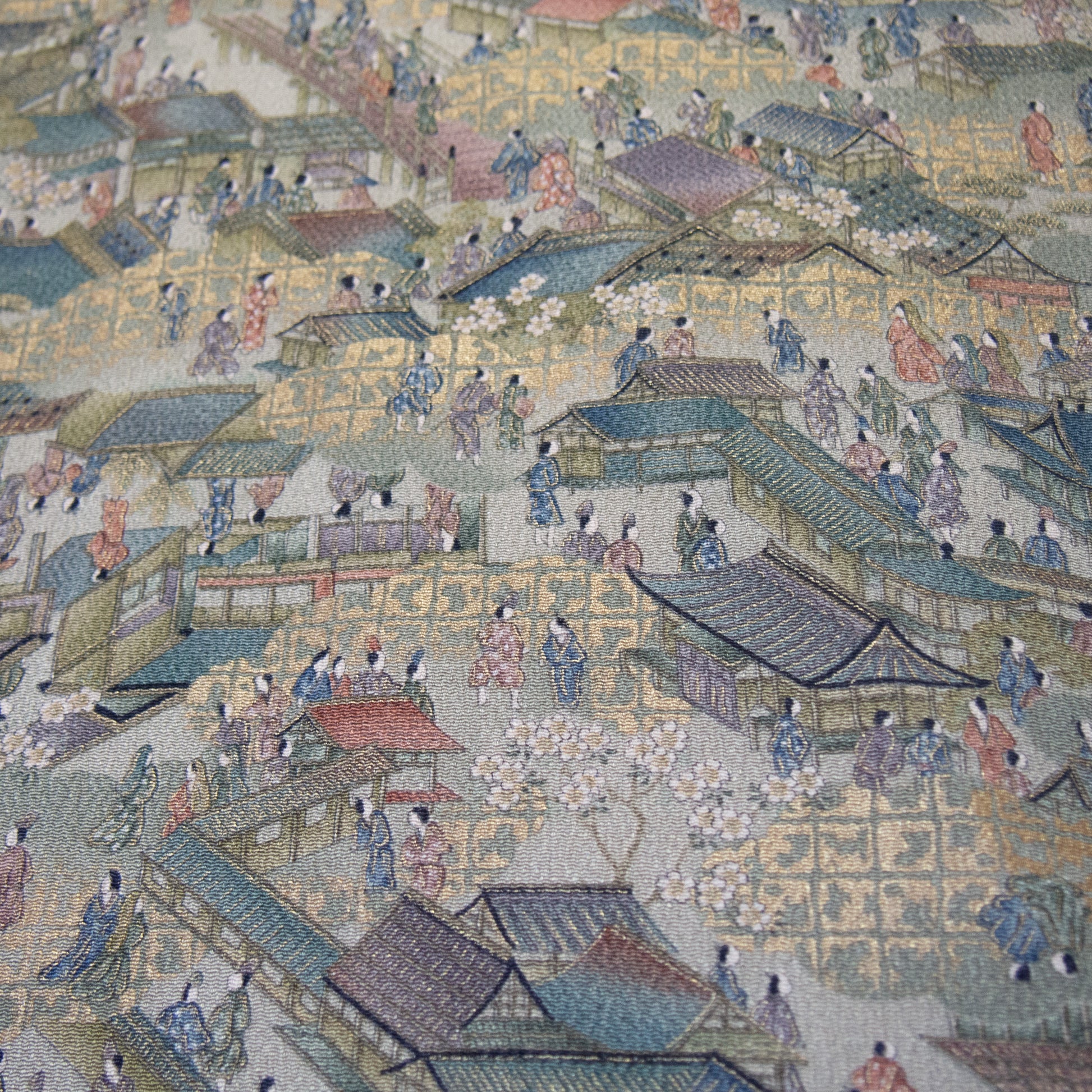 Textured silk kimono fabric with the pattern of people and townscape.